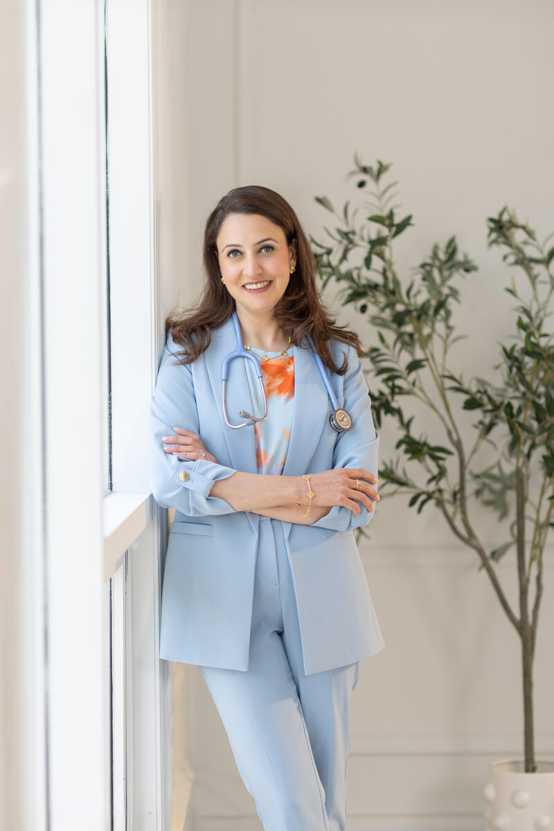 Dr. Farah Siam — Pediatrician standing by window with stethoscope
